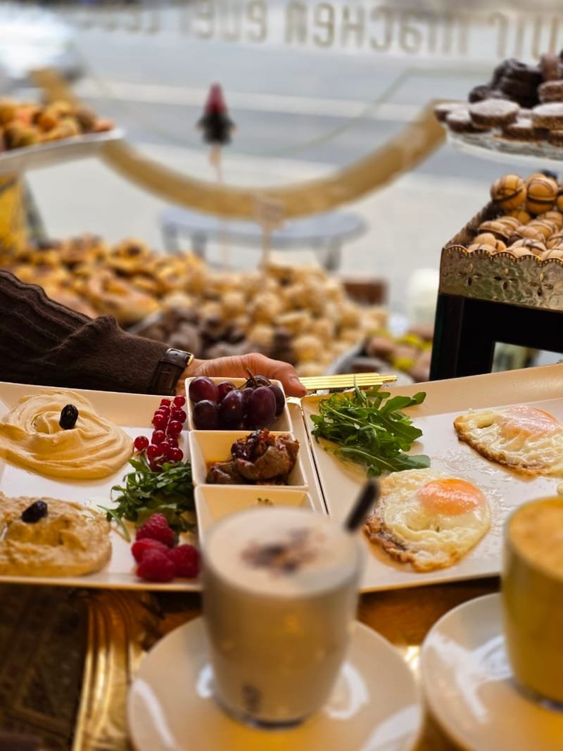 Arabisches Frühstück mit Humus, Spiegeleiern und Latte am Fenstertisch